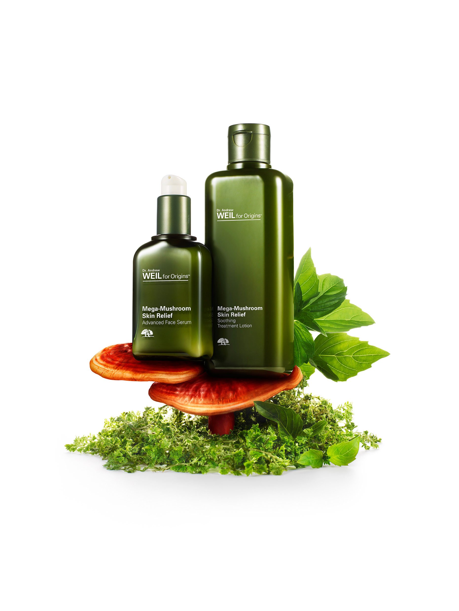Green bottles of Dr. Andrew Weil Mega-Mushroom skin care products on a mushroom, surrounded by green leaves and herbs.